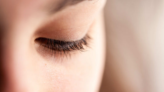 Close-up of a woman's eye with thick, healthy eyelashes showing the benefits of castor oil