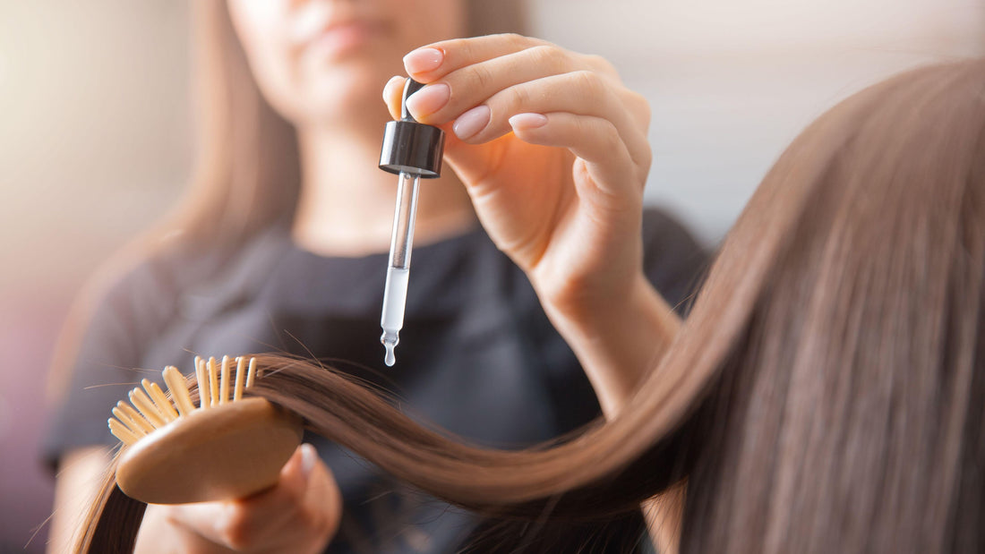 castor oil being applied to hair from a glass dropper for natural hair growth and shine