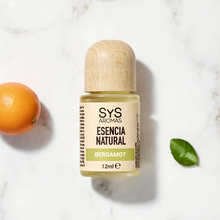 Sys Aromas bergamot essential oil bottle with an orange and leaf on a marble background