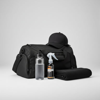 Black duffel bag with a cap, water bottle, towel and playon spray 80ml on a light grey background.