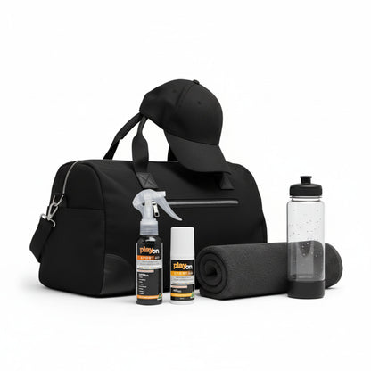 Black duffel bag with a cap, bottles, and playon spray and playon rollon, weekend warrior pack on a white background.
