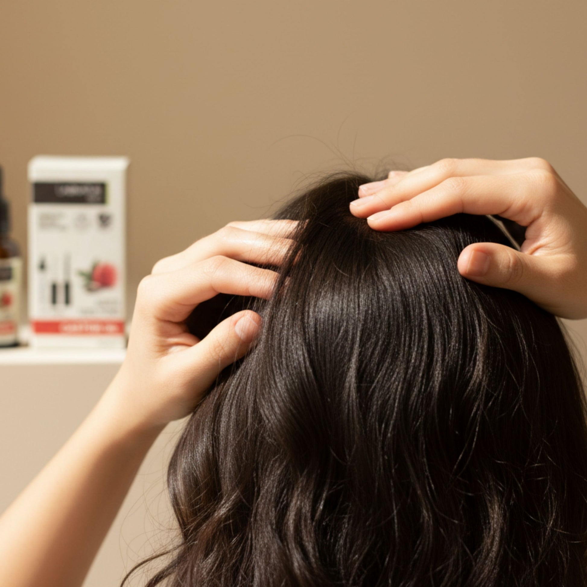 woman applying castor oil to her hair and scalp with her fingers