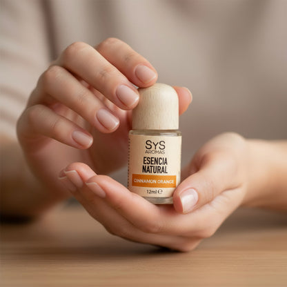 Hand holding bottle of Sys Aromas cinnamon orange essential oil