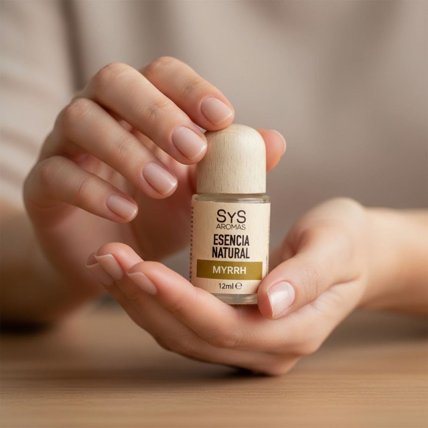 Woman holding a bottle of SYS Aromas Myrrh Essential Oil Home Fragrance in a relaxing setting