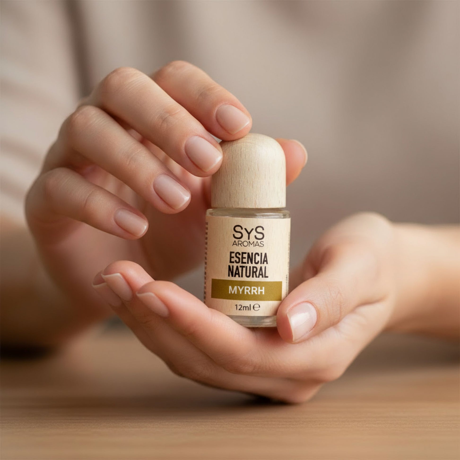 Woman holding a bottle of SYS Aromas Myrrh Essential Oil Home Fragrance in a relaxing setting