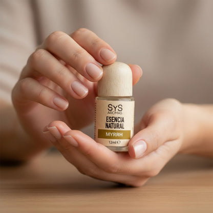 Woman holding a bottle of SYS Aromas Myrrh Essential Oil Home Fragrance in a relaxing setting